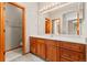 Bathroom with a wood vanity, a white countertop, a large mirror, and modern lighting at 1988 Lake Dr, Larkspur, CO 80118