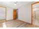 Bedroom with wood-look floors, neutral paint, and a ceiling fan; ensuite bathroom with glass-enclosed shower at 1988 Lake Dr, Larkspur, CO 80118