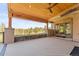 Covered deck with wood ceiling, gas fireplace, and treed views at 1988 Lake Dr, Larkspur, CO 80118