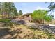 Landscaped yard with a stone and stucco home and a beautiful stairway at 1988 Lake Dr, Larkspur, CO 80118