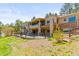 Exterior view of the rear of home with multiple patios and decks with mountain views at 1988 Lake Dr, Larkspur, CO 80118