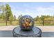 Close up of decorative sphere fire pit with flames on an outdoor patio at 1988 Lake Dr, Larkspur, CO 80118
