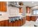 Gourmet kitchen featuring stainless steel range hood and cooktop, and granite countertops at 1988 Lake Dr, Larkspur, CO 80118