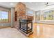 Open living room featuring a beautiful stone fireplace and views from the large windows at 1988 Lake Dr, Larkspur, CO 80118