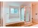 Bright bathroom featuring a soaking tub, walk-in shower, and natural light from the window at 9182 Weeping Willow Ct, Highlands Ranch, CO 80130