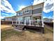 Exterior of home with gray siding, a deck, sliding glass doors, and a lush lawn at 12164 Poplar St, Thornton, CO 80602