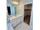 Well-lit bathroom vanity and mirror, next to a walk-in closet at 12164 Poplar St, Thornton, CO 80602