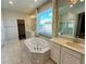 Ensuite bathroom with soaking tub, double sinks, tile floor, and separate shower at 12164 Poplar St, Thornton, CO 80602