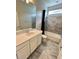 Bathroom featuring a large mirror, a sink with white cabinets and a tiled shower/tub at 12164 Poplar St, Thornton, CO 80602