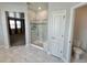 Bright bathroom with tiled shower and glass door near toilet and bedroom at 12164 Poplar St, Thornton, CO 80602