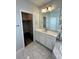 Bright bathroom featuring a white vanity, large mirror, and walk-in closet at 12164 Poplar St, Thornton, CO 80602