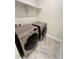 Tiled laundry room featuring a Samsung washer and dryer with an above shelf at 12164 Poplar St, Thornton, CO 80602