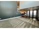 Open-concept living room with carpet, neutral walls, and a view into the kitchen at 12164 Poplar St, Thornton, CO 80602