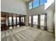 Bright living room featuring large windows, neutral carpet and paint, and an open-concept layout at 12164 Poplar St, Thornton, CO 80602