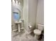 Well-lit powder room featuring a pedestal sink, tiled flooring, neutral walls and a modern toilet at 12164 Poplar St, Thornton, CO 80602