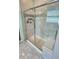 Modern tiled shower with glass door and built-in bench at 12164 Poplar St, Thornton, CO 80602