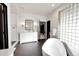 Spa-like bathroom with freestanding soaking tub, white vanity, and dark hexagon tile floor at 44 Spyglass Dr, Littleton, CO 80123