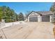 House exterior showcasing a snow-covered driveway and a three-car garage at 44 Spyglass Dr, Littleton, CO 80123