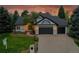 Charming home with a three-car garage, well manicured lawn, professional landscaping and an inviting walkway at 44 Spyglass Dr, Littleton, CO 80123