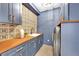 Stylish laundry room with blue cabinets and wood countertops at 44 Spyglass Dr, Littleton, CO 80123