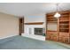 Living room features a brick fireplace with a wood mantle and built in bookcase at 3242 S Oneida Way, Denver, CO 80224