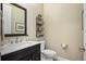 Stylish half bathroom with a modern vanity, elegant mirror, and decorative storage at 350 Andromeda Ln, Castle Rock, CO 80108