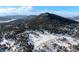 Stunning aerial view of a snow-covered valley with scattered houses and a majestic mountain backdrop at 8537 S Doubleheader Hwy, Morrison, CO 80465