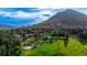 Scenic aerial view of a lush property with rolling green meadows, mature trees, and mountain backdrop at 8537 S Doubleheader Hwy, Morrison, CO 80465