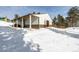 Barn exterior with snow covered driveway, wood storage, and open bay at 8537 S Doubleheader Hwy, Morrison, CO 80465