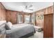 Bedroom features wood paneled walls, ceiling fan, a large bed and natural lighting at 8537 S Doubleheader Hwy, Morrison, CO 80465