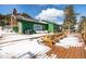 Spacious snow-covered deck features a stone fireplace, built-in seating, and picnic table at 8537 S Doubleheader Hwy, Morrison, CO 80465