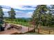 Expansive wooden deck with outdoor seating and stunning views of rolling hills and lush greenery at 8537 S Doubleheader Hwy, Morrison, CO 80465