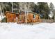 Charming home featuring wood siding, a cozy front porch, and snow-covered landscape at 8537 S Doubleheader Hwy, Morrison, CO 80465