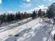 Snowy grounds include a fenced horse training ring with beautiful mature trees at 8537 S Doubleheader Hwy, Morrison, CO 80465