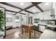 Bright kitchen featuring white cabinetry, dark wood beams, and an island with seating at 8537 S Doubleheader Hwy, Morrison, CO 80465