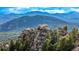 Scenic landscape featuring rock formations and pine trees against a backdrop of rolling hills and a blue sky at 8537 S Doubleheader Hwy, Morrison, CO 80465