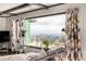 Cozy living room with large window offering scenic mountain views and floral print curtains at 8537 S Doubleheader Hwy, Morrison, CO 80465