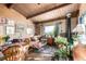 Inviting living room features wood walls, wood-burning stove, and sunny windows framing a scenic view at 8537 S Doubleheader Hwy, Morrison, CO 80465