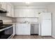 White kitchen with stainless steel appliances and faux marble backsplash at 3047 W 47Th Ave # 506, Denver, CO 80211