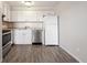 Bright kitchen with white cabinets, stainless steel appliances, and wood-look floors at 3047 W 47Th Ave # 506, Denver, CO 80211