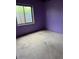 View of a bedroom with lavender colored walls, a window and a concrete floor at 554 E Pleasant Ave, Byers, CO 80103