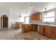 Traditional kitchen with wooden cabinets, tile flooring, and an adjacent dining area at 554 E Pleasant Ave, Byers, CO 80103