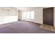 Spacious living room with carpet, lots of natural light, and easy access to front door at 554 E Pleasant Ave, Byers, CO 80103