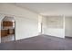Open living area with carpet flooring, neutral walls, and kitchen access at 554 E Pleasant Ave, Byers, CO 80103