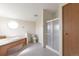 Main bathroom with soaking tub, shower, toilet, and octagon window at 554 E Pleasant Ave, Byers, CO 80103