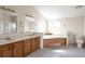The main bath features a soaking tub, shower, dual sinks, and ample lighting at 554 E Pleasant Ave, Byers, CO 80103