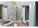 Bathroom with a shower and tub, updated vanity, and wood-like wall accents at 1440 Little Raven St # 204, Denver, CO 80202