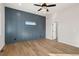 Spacious bedroom with wood floors, a ceiling fan and stylish blue accent wall at 1369 Burt Ave, Berthoud, CO 80513