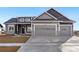 Two-story home with gray siding, stone accents, and a two-car garage at 1369 Burt Ave, Berthoud, CO 80513