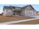 Two-story home with gray siding, stone accents, and a two-car garage at 1369 Burt Ave, Berthoud, CO 80513